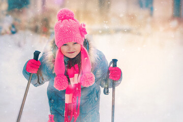 little beautiful girl with ski poles smiling