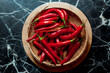 Red fresh spicy chili in vintage bamboo rattan bowl on background on table
