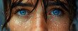 Emotional close up portrait of young woman with blue eyes and wet hair looking up