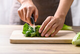 Fototapeta  - Organic cos romaine lettuce cutting on wooden board, Food ingredient for healthy salad