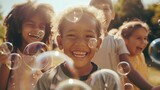 Fototapeta  - Multi-ethnic group of little friends with toothy smiles on their faces enjoying warm sunny day while participating in soap bubbles show