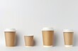 Collage of various sized paper coffee cups white background