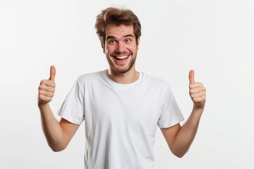 Wall Mural - Cheerful man in white t shirt showing thumbs up while standing