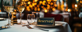 Fototapeta  - Elegant reserved sign placed on a white linen tablecloth at a fine dining restaurant, with wine glasses and bokeh lights in the background, creating a sophisticated and exclusive atmosphere