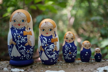 Wall Mural - Figurines of beautiful dolls in the forest. Matryoshka dolls.