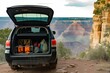 black suv with open trunk, camping gear inside, cliffside view