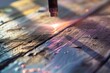 closeup of laser beam removing paint from a wooden plank