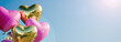 Banner pink and gold heart shaped helium balloons with metallic glitter flying into the blue sky, with space for text. Holidays, birthdays, surprise, party, decoration, valentine