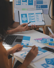 Close up ux developer and ui designer use augmented reality brainstorming about mobile app interface wireframe design on desk at modern office.Creative digital development agency