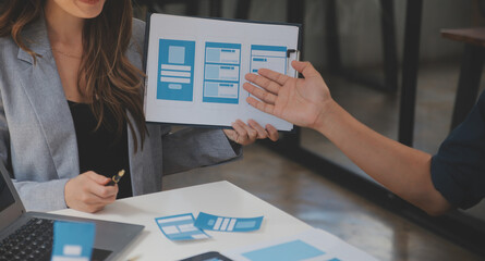 Close up ux developer and ui designer use augmented reality brainstorming about mobile app interface wireframe design on desk at modern office.Creative digital development agency