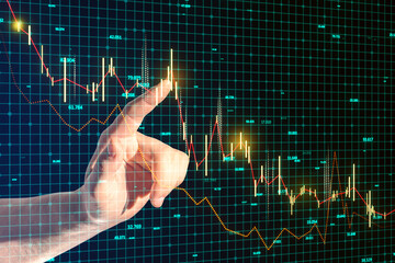 Wall Mural - Close up of businessman hand pointing at glowing and growing business chart on blurry blue grid background. Financial growth, trade and stock concept.