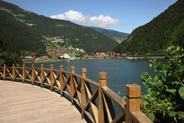 Sticker - Buildings under mountains near lake on sunny day