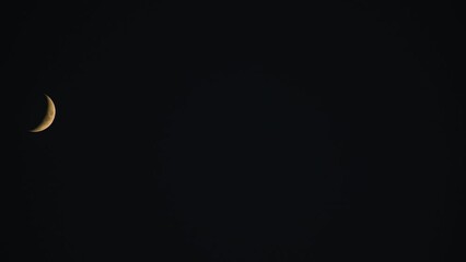 Wall Mural - crescent moon on night time sky travelling from left to right side.