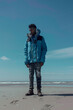 © SergIO - a man in a blue jacket on the beach, generative ai