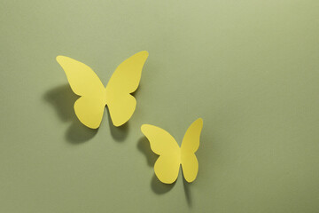 Sticker - Yellow paper butterflies on pale green background, top view. Space for text