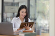 © SOMKID - Happy asian young businesswoman using digital tablet  sitting in office working space.
