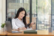 © SOMKID - Happy asian young businesswoman using digital tablet  sitting in office working space.