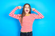 Photo of crazy Young kid girl wearing striped t-shirt screaming and pointing with fingers at hair closed eyes