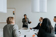 © Maskot - Mature businesswoman explaining strategy while discussing with colleagues in board room during meeting