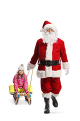 Wall Mural - Santa claus walking towards camera with a child on a sled