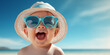 Cute little smiling boy in sun hat and sunglasses on the beach. Banner with copyspace. Shallow depth of field.