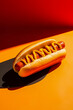 © ADDICTIVE STOCK - Classic hot dog with mustard on a vibrant background Generative AI image
