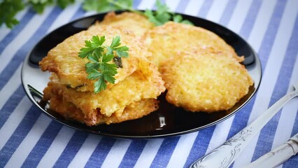 Wall Mural - fried vegetarian potato pancakes, in a plate on a fabric tablecloth