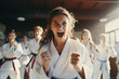 Junge Karatekas mit neuen Gürteln nach bestandener Prüfung im Dojo
