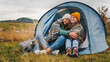 © olezzo - Two lesbian couple friends traveling together to the mountains sitting hugging in a tent. Camping active lifestyle travel