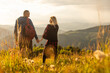 travel to mountains, tourists hikers with backpacks at sunset enjoying panoramic view