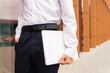 © ADDICTIVE STOCK - Close-up of a professional anonymous man in a white shirt and navy pants holding a laptop, ready for a productive business day