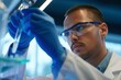 technician examines liquid vial in lab