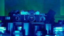 Vintage Collection Of Antique Cameras And Lenses. Immerse Yourself In An Atmosphere Of Mystery And Magic With This Video Where Vintage Cameras And Lenses Are Enveloped In Neon Light And Smoke.