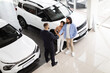© Prostock-studio - Young indian loving couple buying car at luxury auto dealership