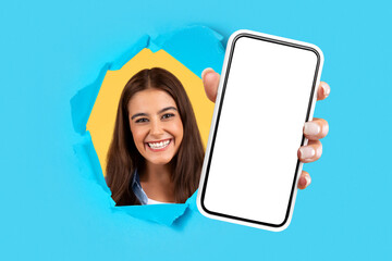 Poster - Happy woman holding cellphone in hand breaking through blue paper