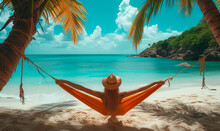 Happy Beautiful Girl In A Straw Hat And Shorts, Striped T-shirt, Lying On A Beach Hammock Between Two Palm Trees, On The Seashore Of A Tropical Island.
