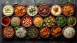 Assorted Indian food in bowl or plate includes Chicken Tikka Masala, Dal Makhana, Palak Paneer, Chickpea, Dry Fruits, Vegetables, Herbs and spices. Top view