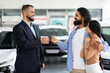 © Prostock-studio - Millennial eastern spouses buying new automobile at showroom store
