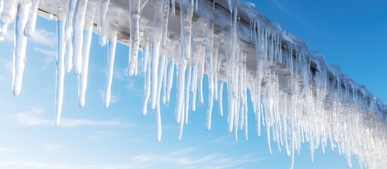 Fototapete - Sharp icicles and melted snow hanging from eaves of roof Beautiful transparent icicles slowly gliding of a roof. Creative Banner. Copyspace image