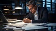 © arayabandit - Dedicated business professional engrossed in work amid business documents, exemplifying focused determination and commitment to tasks in a well-organized workspace.
