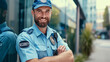 © MP Studio - smiling security guard with a beard, standing confidently with his arms crossed