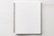a white notebook with a spiral bound on a white surface