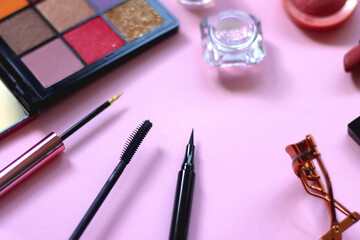 Wall Mural - Various colorful make up products on pastel pink background. Selective focus.