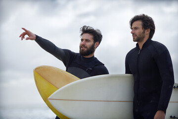 Wall Mural - Man, friends and surfer pointing on beach for fitness, sport or waves on shore in outdoor exercise. Young male person or people with surfboard for surfing challenge or hobby on ocean coast in nature