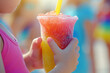 Close up of a child holding a cold slushy crushed ice drink