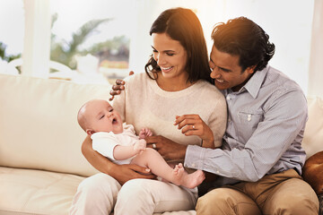 Poster - Happy family, baby and hug on sofa for bonding, support or love together in relax at home. Father and mother holding little child, kid or newborn toddler on living room couch with smile at house