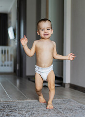 Wall Mural - Small child is walking in diapers in the room