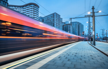 Wall Mural - high speed train in motion on the railway station at sunset