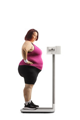 Canvas Print - Corpulent woman in sportswear standing on a medical weight scale