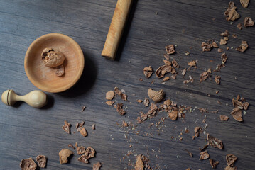 Wall Mural - Comida. Nueces Chandler, mesa de madera donde se rompen las cascaras en un recipiente de madera con golpes y un triturador de nueces, las cascaras esparcidas por medio, plano.